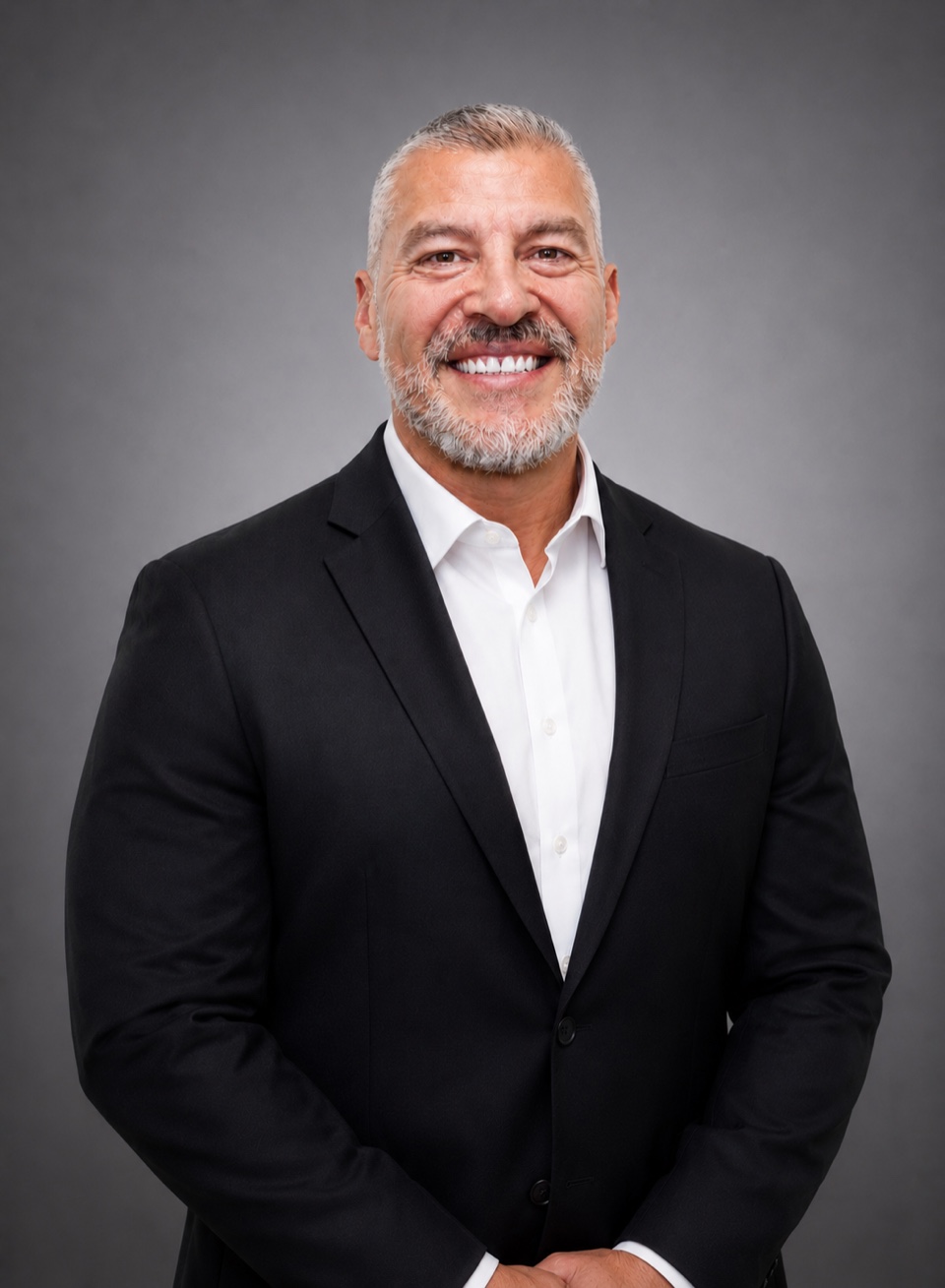 Jay Tapia smiling in a black suit